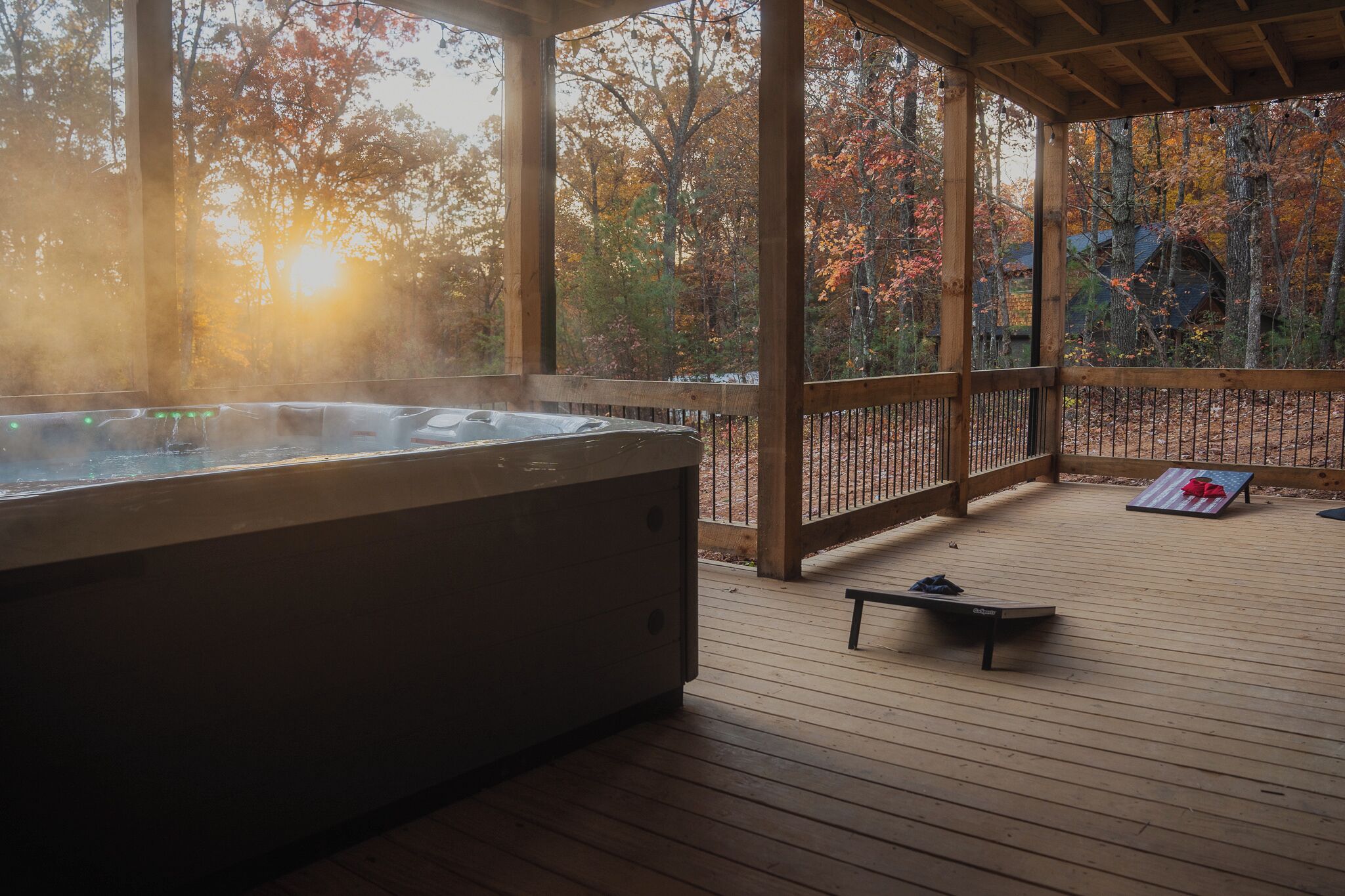 Een hottub op een houten terras, met uitzicht op herfstbomen.