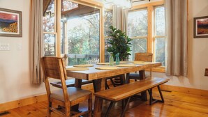 A wooden dining table with four chairs, a bench, and a potted plant. - McStay in McCay - Charming 4-bed cabin w/ outdoor fireplace and large jacuzzi!  (McCaysville)