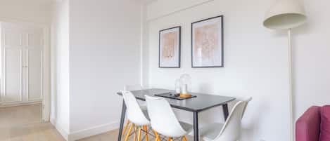 A dining area with a table, chairs, and two framed calligraphy pieces on the wall.