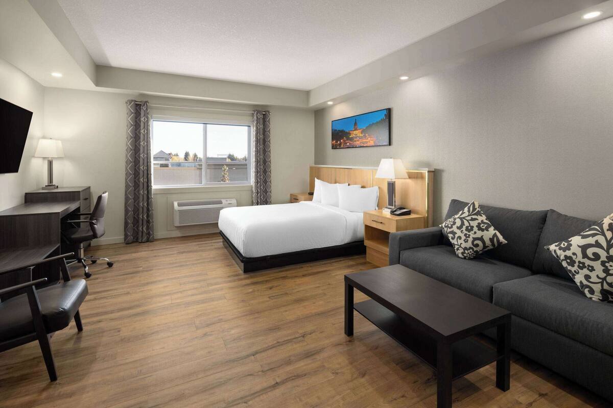 Een hotelkamer met een bed, een bank, een bureau en een stoel.