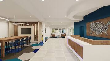 A modern hotel lobby with a reception desk, seating area, and a large wall art piece.