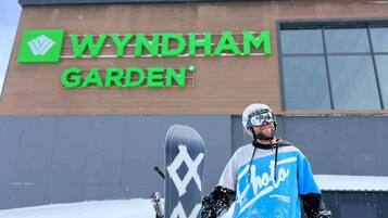 A person standing in front of a building with a sign that reads 'WYNDHAM GARDEN'.