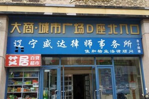 A storefront with a blue signboard and a red signboard advertising a 100 yuan discount.