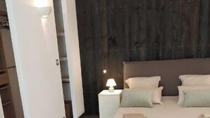 A bedroom with a bed, bedside table, and a nightstand. - Bright, quiet apartment with private pool (Vaison-la-Romaine)