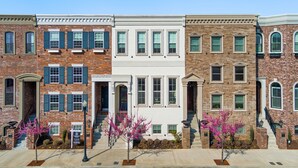 Una hilera de casas urbanas con fachadas de ladrillo, detalles en blanco y múltiples ventanas.