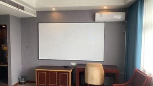 Ett rum med en whiteboardtavla, ett träskåp, ett skrivbord och en stol.