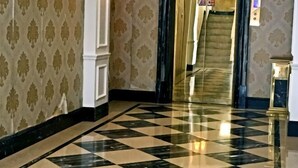 A checkered floor, a staircase, and patterned wallpaper in a hallway. - Xindu Hotel (Wenzhou)