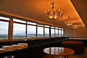 A room with large windows, a chandelier, and a round table. - Xindu Hotel (Wenzhou)