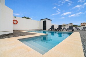 A swimming pool with lounge chairs, a lifebuoy, and a small building. - The Rock Hostel (Ponta Delgada)