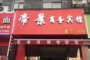 Fachada roja con caracteres chinos y un número de teléfono.