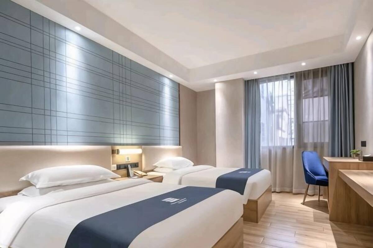 Una habitación de hotel con dos camas, un escritorio y una silla.