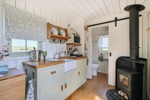 Una cocina con una isla central, armarios de madera, una estufa y vistas al exterior.