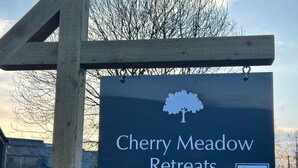 Un panneau représentant la silhouette d’un arbre et portant l’inscription « Cherry Meadow ».