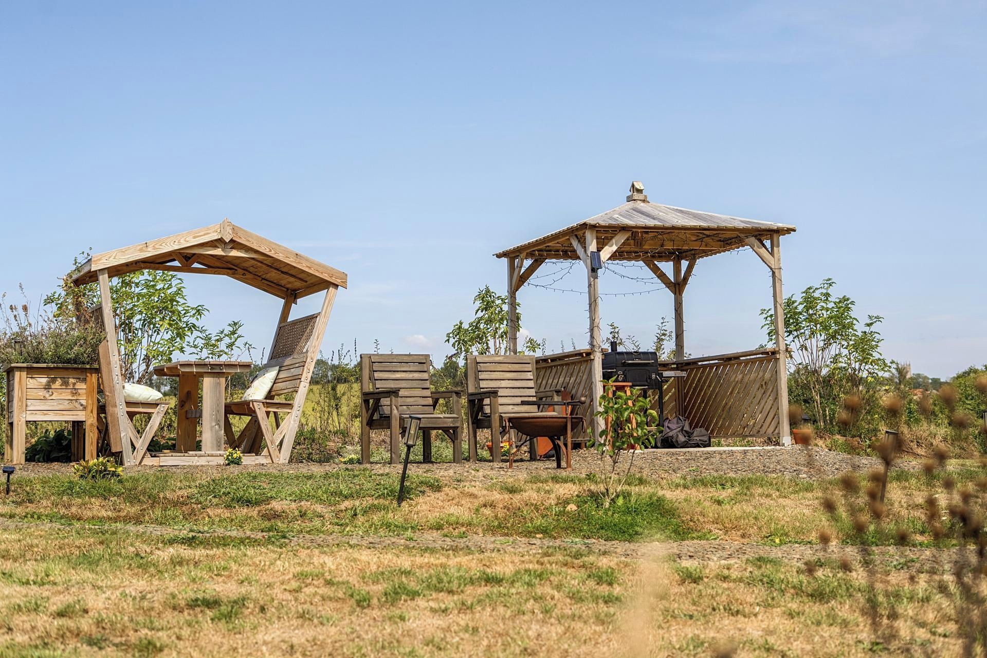 A rustic outdoor seating area with wooden structures and chairs.