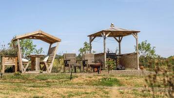 A rustic outdoor seating area with wooden structures and chairs.