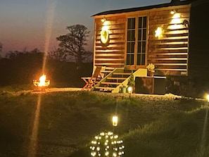 A wooden cabin with a porch, steps, and a fire pit. - Cosy Luxury Foxglove Hut With Private Fire Bowl (Umberleigh)