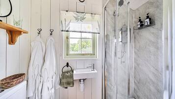 A bathroom with a shower, a sink, and a window with a view.
