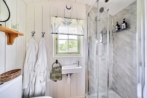 A bathroom with a shower, a sink, and a window with a view. - Cosy Luxury Foxglove Hut With Private Fire Bowl (Umberleigh)