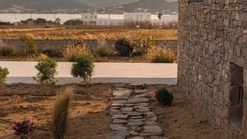 A stone building with a stone pathway leading to a white building in the background.