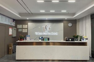 A reception desk with a logo, a clock, and framed certificates on the wall.
