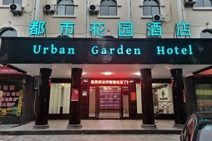 La entrada del Hotel Jardín Urbano, con un letrero destacado y un acceso por puerta de vidrio.