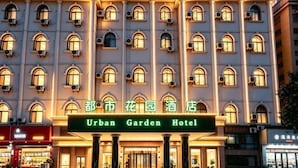 Un immeuble à plusieurs étages sur lequel on peut lire l’inscription : « Hôtel Urban Garden ».
