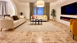 A modern living room with a sofa, coffee table, and a fireplace.