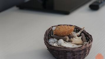 Un panier en osier contenant divers objets, posé sur une surface en bois de couleur claire.