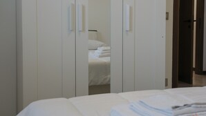 A hotel room with a bed, a wardrobe, and a mirror. - Apt24 - The Roof in Desenzano del Garda (Desenzano del Garda)