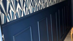A hallway with a geometric patterned wall, dark blue wainscoting, and wooden flooring. - Chambre en Autonomie Endroit Calme! Idéal Marcheurs, Vélo, Moto! Garage Dispo (Ugny-sur-Meuse)