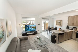 Una sala de estar moderna con un sofá, una mesa de centro y un televisor de pantalla plana.