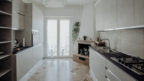 Eine moderne Küche mit einer zentralen Kochinsel, integrierten Geräten und einem großen Fenster.