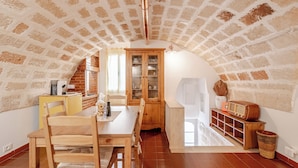 Eine gemütliche Küche mit Holztisch, Stühlen und einem Schrank.