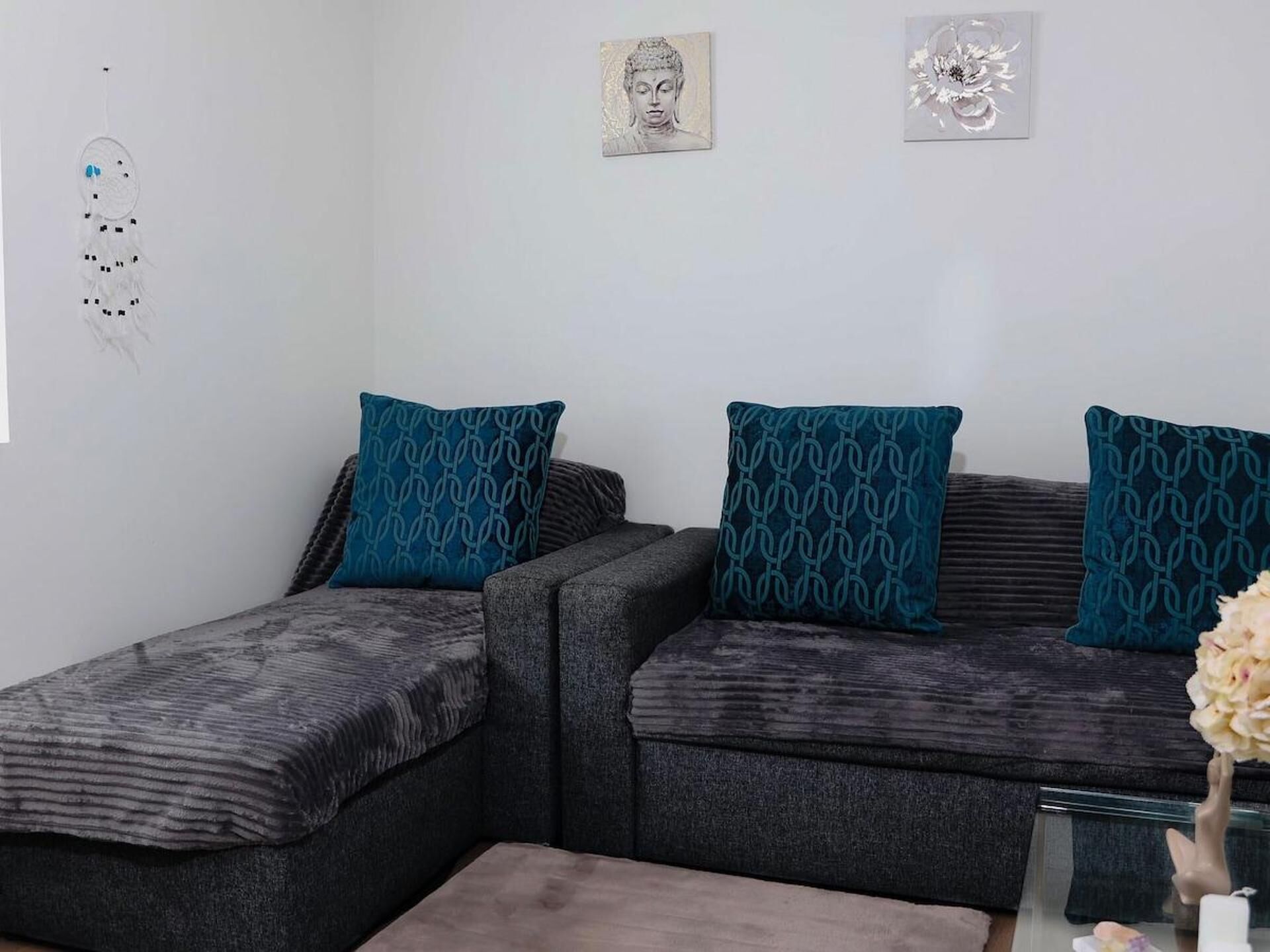 Un salon moderne avec deux canapés, chacun agrémenté d’un coussin à motifs, et une petite table sur laquelle est posé un vase.