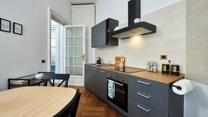 A modern kitchen with a wooden table, dark cabinets, and a built-in oven. - Spacious dwelling between Vatican and Center [3 bedrooms, 3 baths] (Roma)