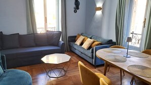 A living room with a sofa, a coffee table, and a dining table with chairs. - Spacious dwelling between Vatican and Center [3 bedrooms, 3 baths] (Roma)