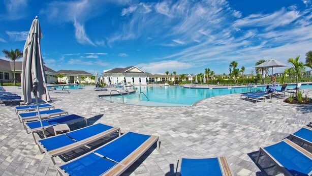 Un espace aménagé au bord de la piscine, avec des chaises longues et une piscine.