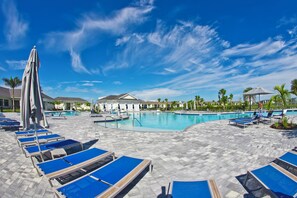 A poolside area with lounge chairs and a swimming pool. - Luxurious Condo in Babcock w/ Golf, Heated Pools, Hot Tub, Pickle ball, & Tennis (Punta Gorda)