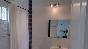 A bathroom with a toilet, sink, and a mirror with a plant. - HOTEL CAMPESTRE EL SALITRE (Villeta)