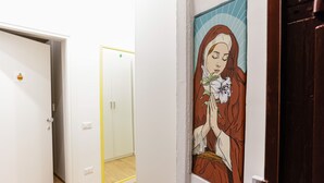 A hallway with a door featuring a religious-themed artwork. - Santa Patrizia a Chiaia Apartment - Terra (Naples)