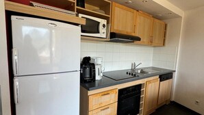 A compact kitchen with a refrigerator, microwave, coffee maker, and dishwasher. - Ski-in/ski-out & foot of the slopes, 4th floor, view ski slopes, swimming pool, balcony, tv (La Plagne)
