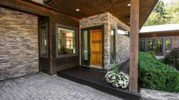 A modern house with a stone facade, large windows, and a wooden door.