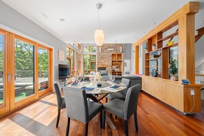 Una cocina moderna con comedor, ventanas amplias y una pared de acento de piedra.