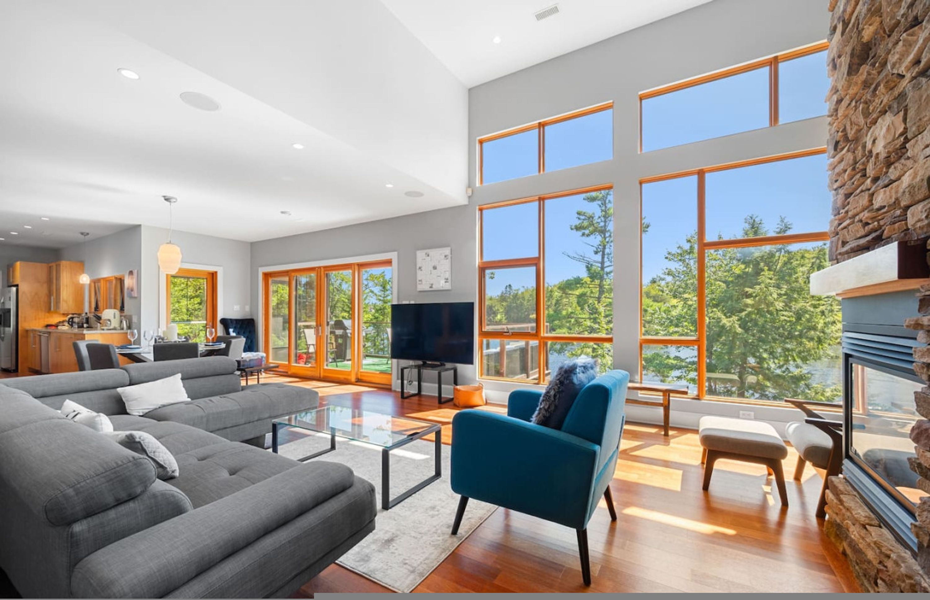 A spacious living room with a large TV, comfortable seating, and a fireplace.