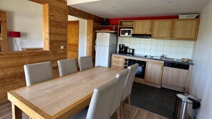A compact kitchen with wooden cabinets, a microwave, and a refrigerator. - Ski-in/ski-out & foot of the slopes, 7th floor, view ski slopes, swimming pool, balcony, tv (La Plagne)