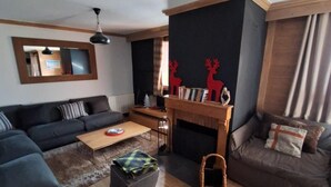 A modern living room with a sofa set, a coffee table, and a fireplace.