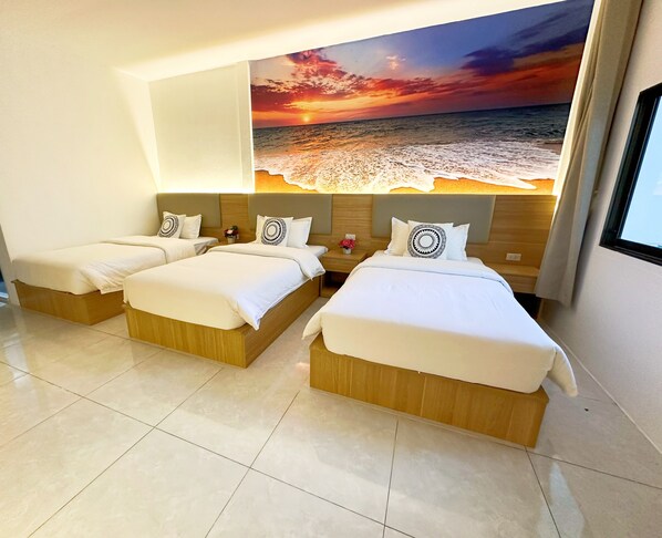 A hotel room with two beds, a large wall mural of a sunset over the ocean, and a window with curtains. - The Coconut Resort Hotel (Patong)