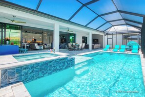 Un área interior de piscina moderna con techo de cristal, zona de comedor y bar.