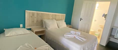 A hotel room with two beds, a wooden headboard, white bedding, and a ceiling fan.
