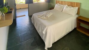 A bedroom with a bed, a ceiling fan, a wall-mounted macrame piece, and a view through an open door. - Pousada Quintal da Praia  (Prado)